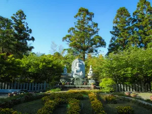 A serene buddha statue sits in a garden. jigsaw puzzle