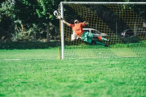 man in red shirt and black pants playing soccer during daytime jigsaw puzzle