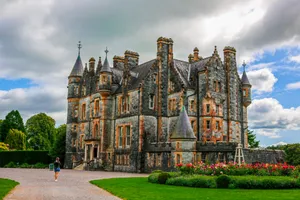 a large castle like building sitting on top of a lush green field jigsaw puzzle