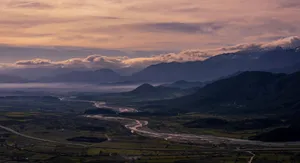 Breathtaking aerial view of a mountain valley at sunrise, with a winding river and misty clouds. jigsaw puzzle