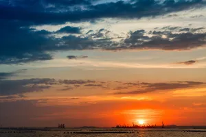 Epic sunset view over the sea with silhouettes of industrial cranes on the horizon. jigsaw puzzle