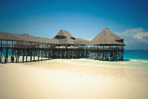Idyllic tropical beach scene with traditional nipa huts on stilts over turquoise waters, perfect for a summer vacation. jigsaw puzzle