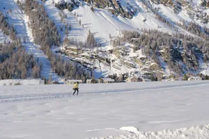 A skier glides across a snowy landscape with scenic mountains in the background. jigsaw puzzle